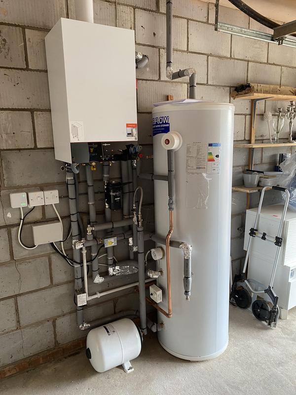 Wall-mounted high-efficiency boiler installed alongside an unvented hot water cylinder with magnetic filter