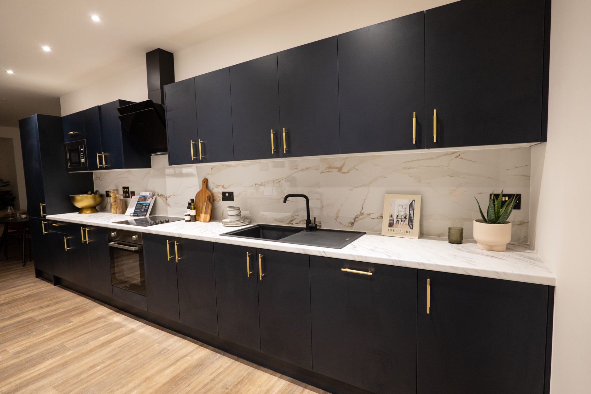 Navy kitchen with marble worktops and brass handles